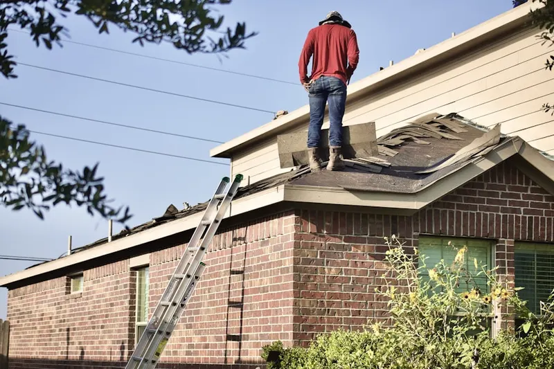 Professional roofer working on a residential roof in Bayou Club